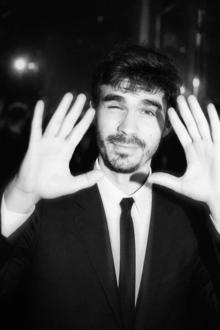 Retrato de Enrike Segarra, en blanco y negro, enmarcando su cara con las manos